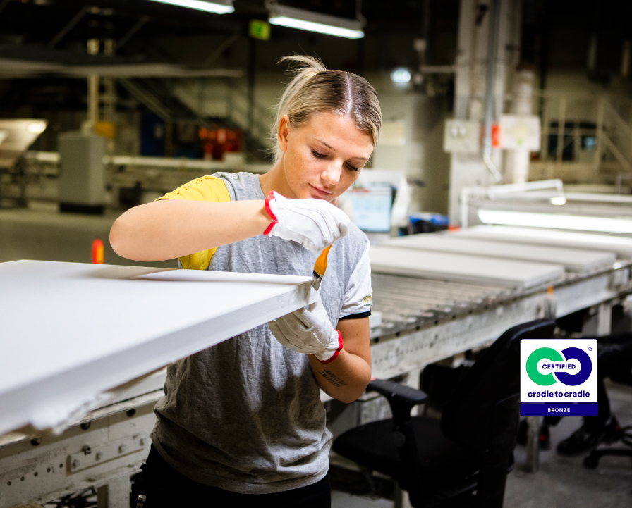 Female Ecophon co-worker inspecting an acoustic panel at the production line