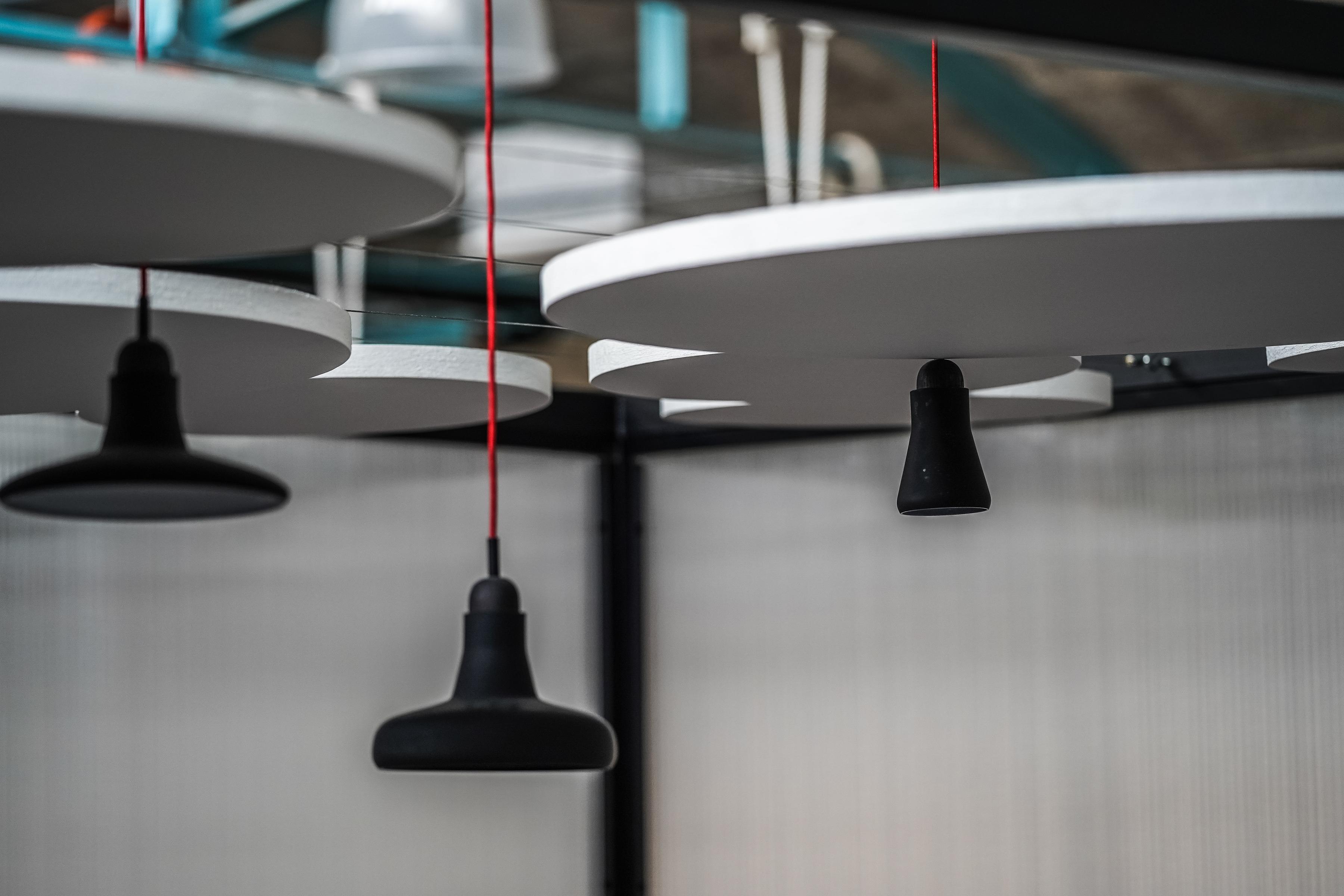 Close-up of free-hanging acoustic panels and lamps
