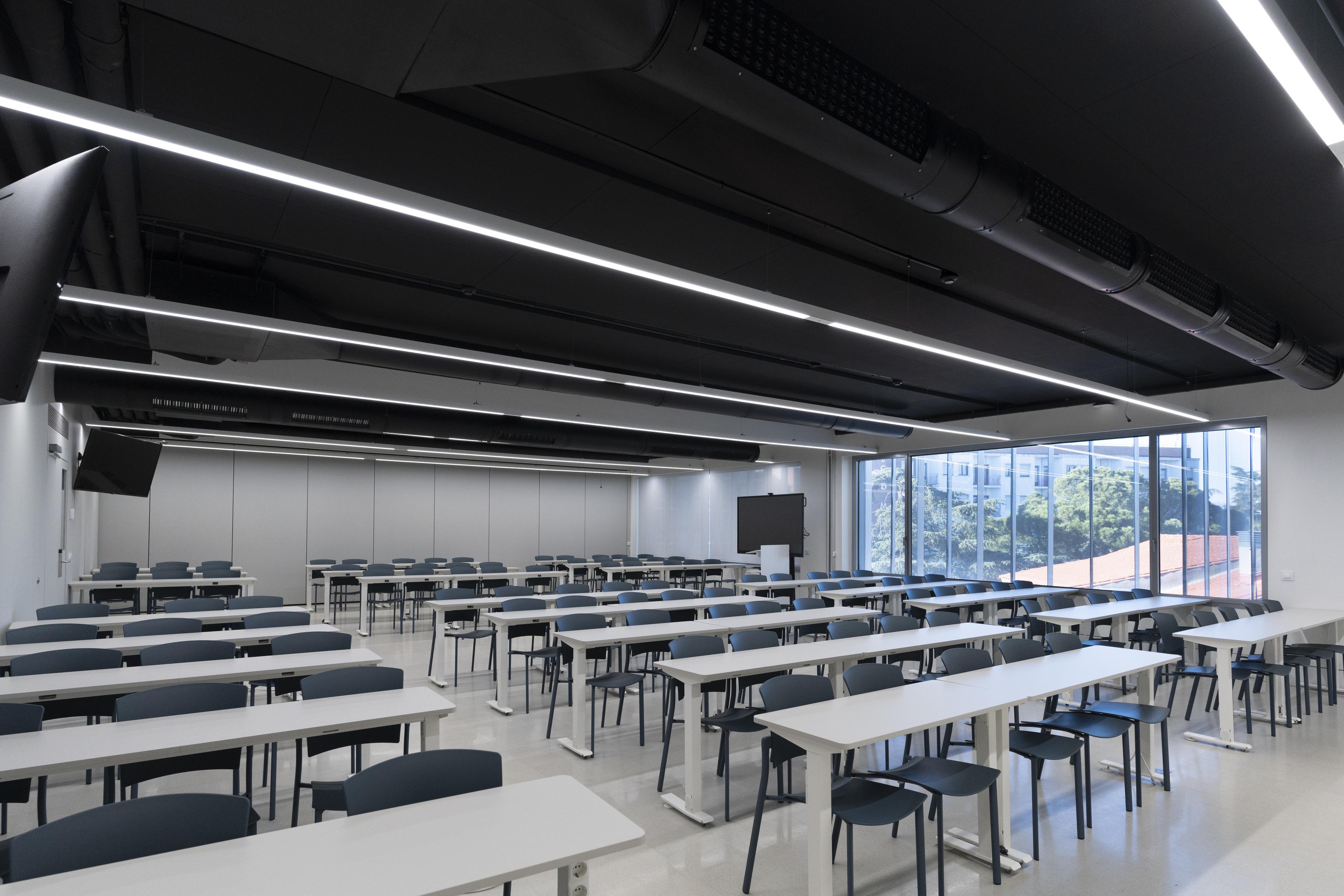 Black acoustic ceiling fixed directly to the soffit in university lecture hall