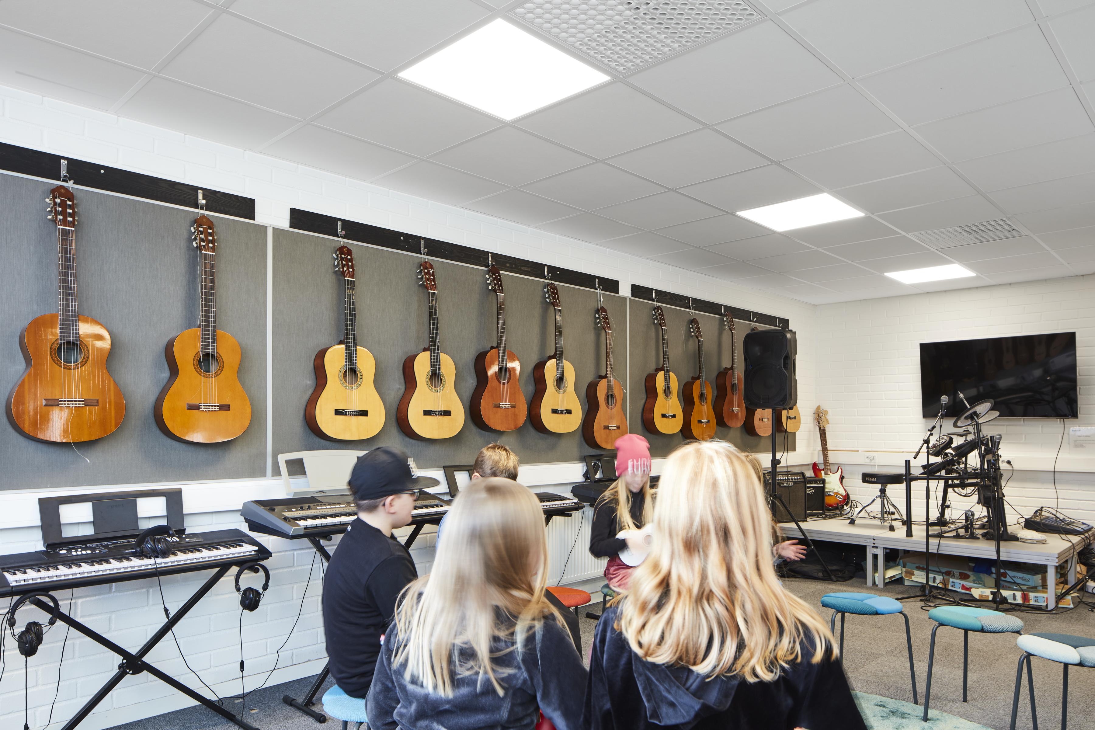 Pupils in music room with suspended acoustic ceiling.