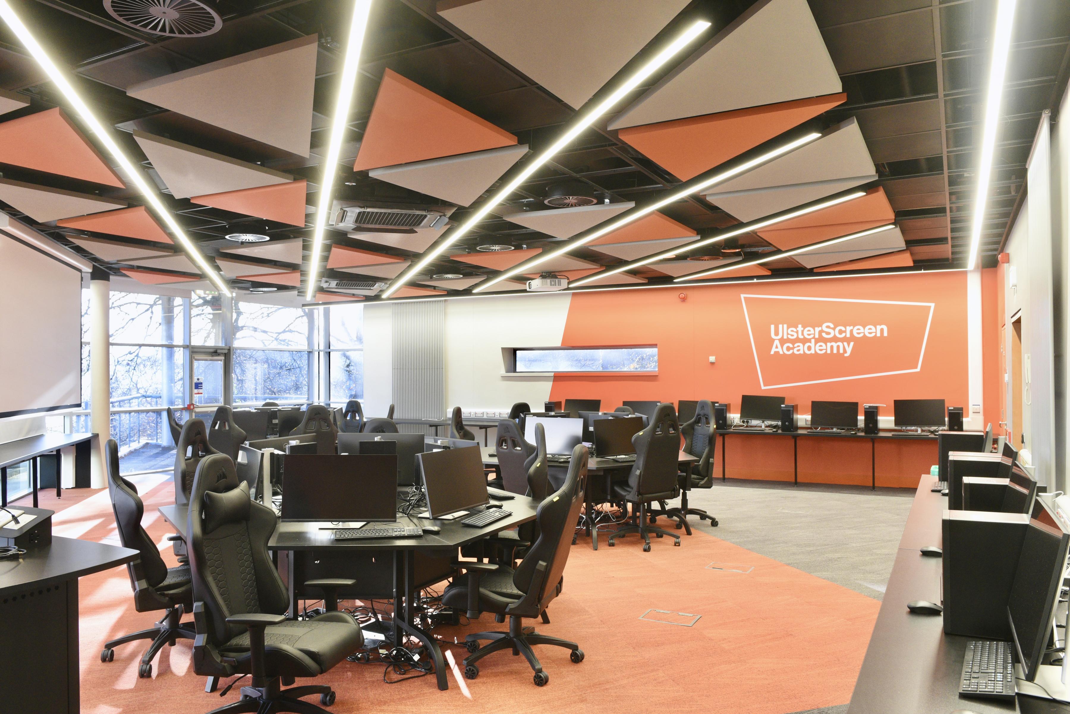 Triangle-shaped, free-hanging acoustic panels in different colours in computer science classroom