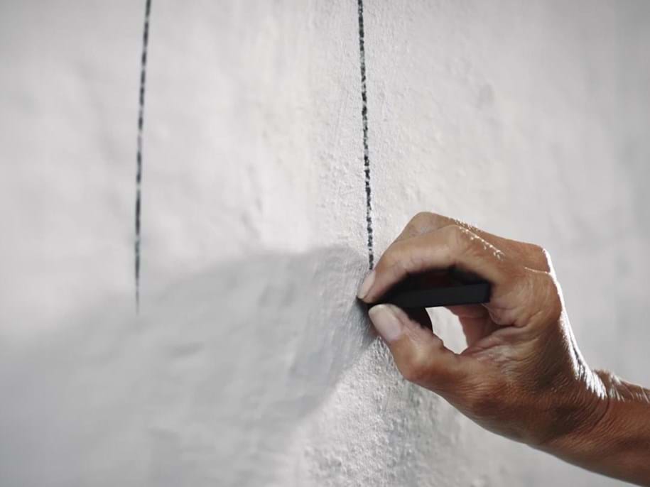 Close-up of hand making a sketch on a wall